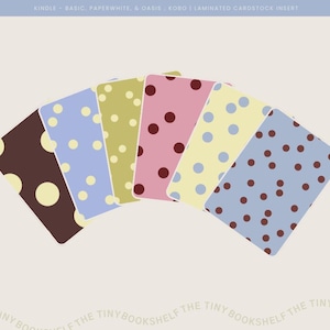 May include: Six rectangular laminated cardstock inserts for Kindle and Kobo e-readers, arranged in a fan shape. Each insert features a unique color combination with polka dot patterns, including brown, blue, olive green, pink, and yellow variations.
