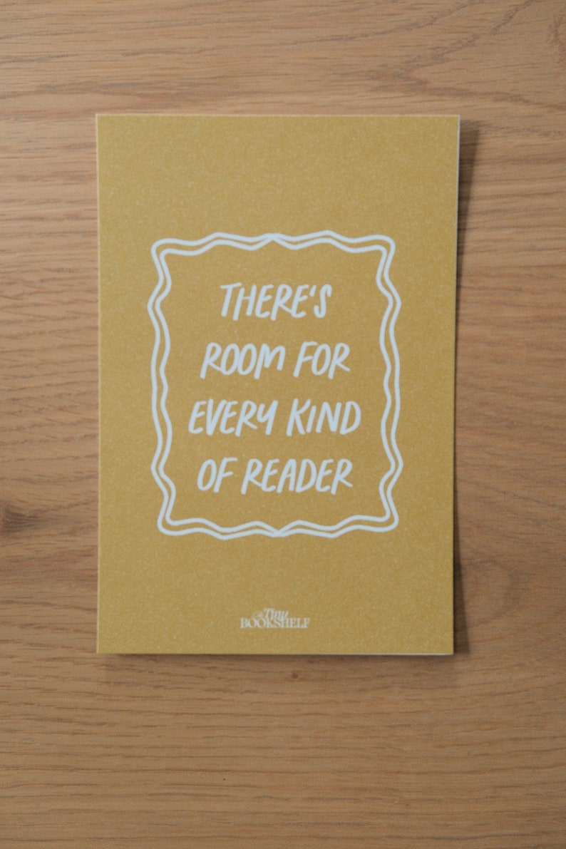 May include: A yellow card with white text that reads "There's room for every kind of reader" in a decorative frame. The text "Tiny Bookshelf" is at the bottom of the card.
