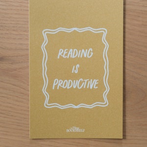 May include: A yellow card with a white border and the text "Reading is Productive" inside. The text "Tiny Bookshelf" is at the bottom of the card.