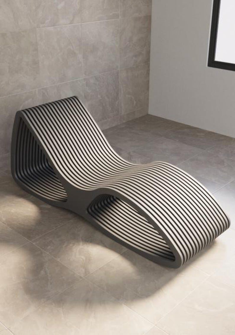 Puede incluir: Una tumbona moderna con un dise&ntilde;o &uacute;nico. La silla presenta un marco gris oscuro con listones horizontales y paralelos en blanco y negro alternados. La forma curva y el dise&ntilde;o abierto crean una est&eacute;tica contempor&aacute;nea.