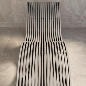 Puede incluir: Una moderna tumbona gris para exteriores con un dise&ntilde;o de listones. La silla presenta un respaldo y un asiento curvos, construidos con listones verticales y espaciados uniformemente. La silla se encuentra sobre un fondo neutro y embaldosado.