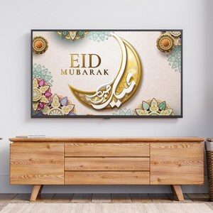 K&ouml;nnte beinhalten: Ein Fernsehbildschirm zeigt einen festlichen Eid Mubarak-Gru&szlig; mit einem Halbmond und komplizierten floralen Designs in Gold, Gr&uuml;n und Rosa.