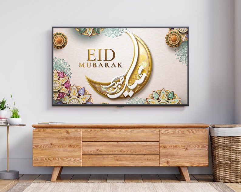 K&ouml;nnte beinhalten: Ein Fernsehbildschirm zeigt einen festlichen Eid Mubarak-Gru&szlig; mit einem Halbmond und komplizierten floralen Designs in Gold, Gr&uuml;n und Rosa.