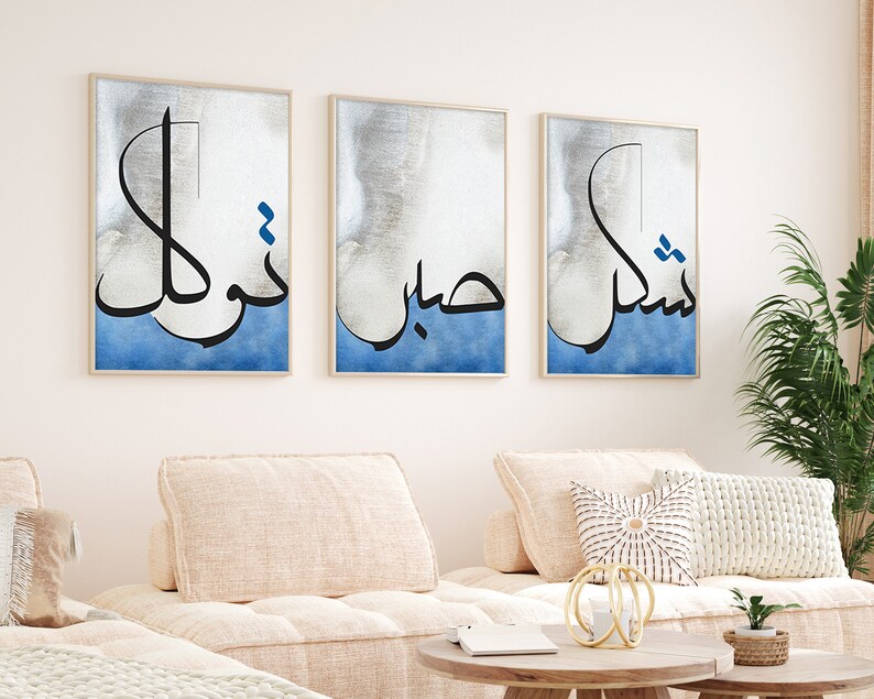 K&ouml;nnte beinhalten: Drei gerahmte Drucke mit arabischer Kalligraphie in Schwarz auf einem blauen und wei&szlig;en Aquarellhintergrund. Der Text lautet "Nishma", "Habib" und "Nukhl".
