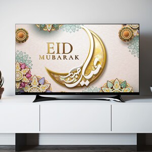 K&ouml;nnte beinhalten: Ein Fernsehbildschirm zeigt einen festlichen Eid Mubarak-Gru&szlig; mit einem goldenen Halbmond und komplizierten floralen Designs in Gr&uuml;n-, Blau- und Rosat&ouml;nen.