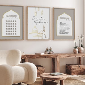 May include: Three printable Ramadan themed posters with gold accents. The first poster is a calendar with the days of Ramadan numbered in gold. The second poster features a mosque with a gold outline. The third poster has a list of Ramadan roles with gold accents.