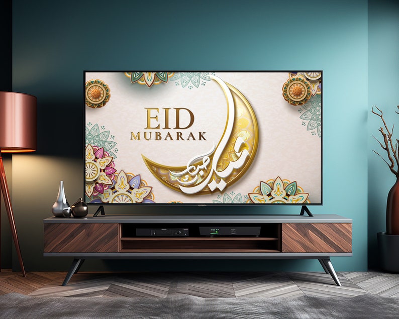 K&ouml;nnte beinhalten: Ein Fernsehbildschirm zeigt einen festlichen Eid Mubarak-Gru&szlig; mit komplizierten goldenen und bunten Mandala-Designs. Der Bildschirm ist an einem dunklen Holz-Entertainment-Center mit einem Regal befestigt.
