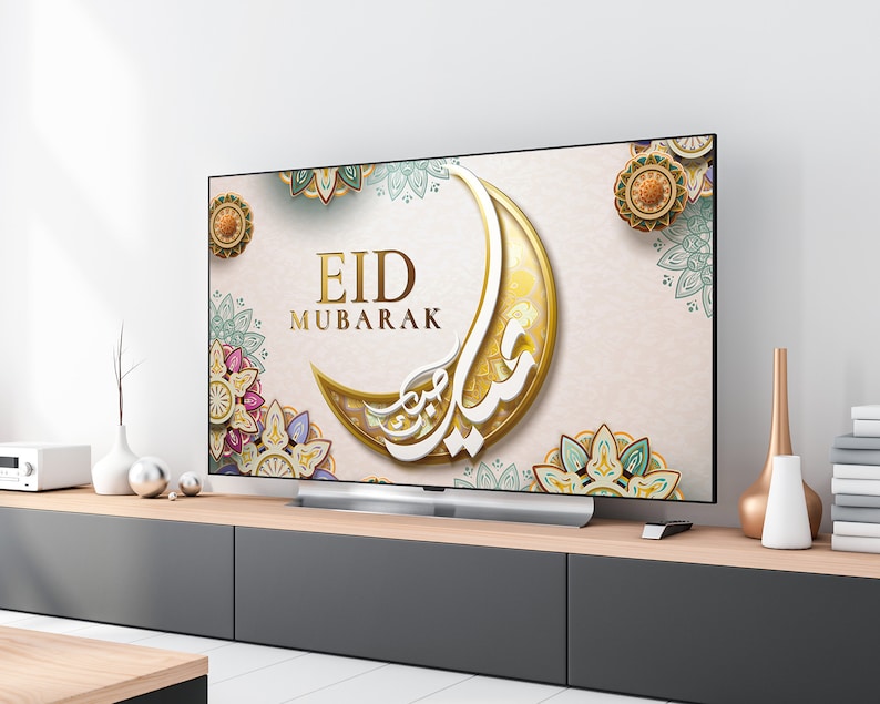 K&ouml;nnte beinhalten: Ein Fernsehbildschirm zeigt einen festlichen Eid Mubarak-Gru&szlig; mit einem Halbmond und komplizierten floralen Designs in Gold, Gr&uuml;n und Rosa.
