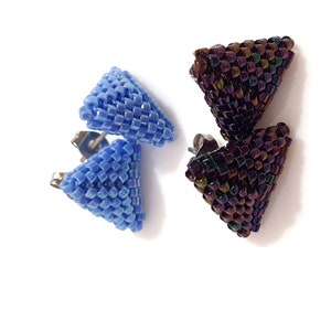 Könnte beinhalten: Ein Paar dreieckige Ohrringe, einer blau und einer schillernd violett. Die Ohrringe bestehen aus kleinen Perlen und haben einen silbernen Stift.