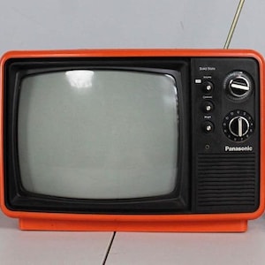 May include: A retro Panasonic television with an orange surround and a black front. The TV features a small screen, control dials, and an aerial. The words "Solid State" and "Panasonic" are visible.