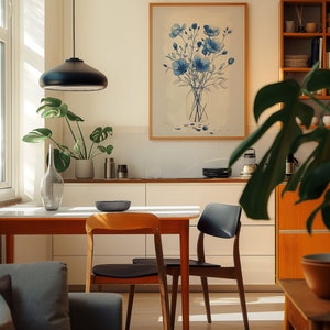A cosy corner of a neutral wood kitchen with sunlight streaming in. A large framed artwork in on the wall