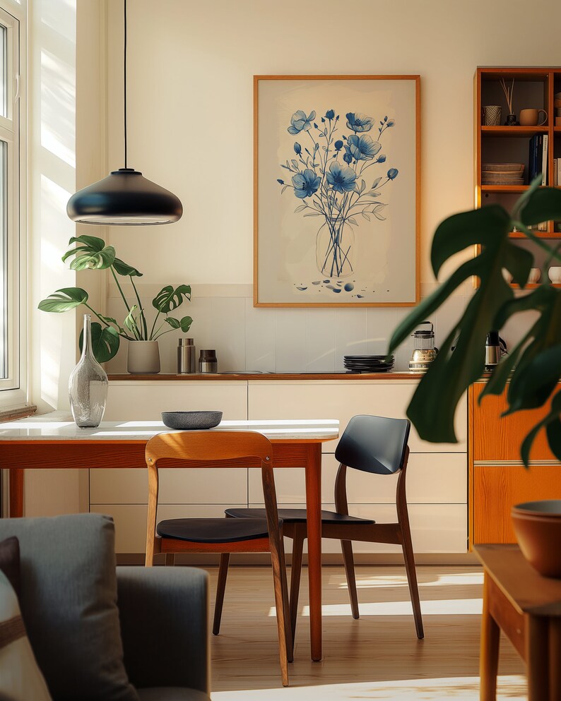A cosy corner of a neutral wood kitchen with sunlight streaming in. A large framed artwork in on the wall