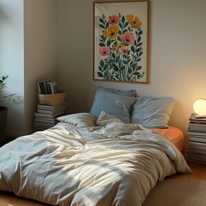 A dark moody bedroom with a floor bed. A large wood oak frame in on the wall above the bed.