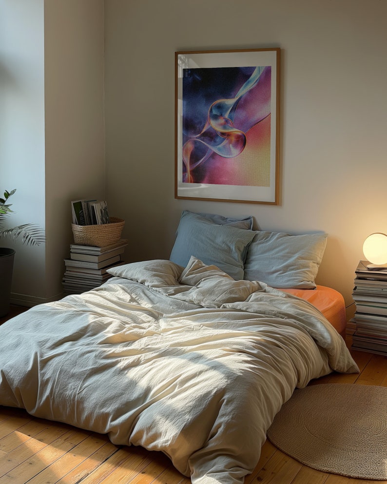 A dark moody bedroom with a floor bed. A large wood oak frame in on the wall above the bed.