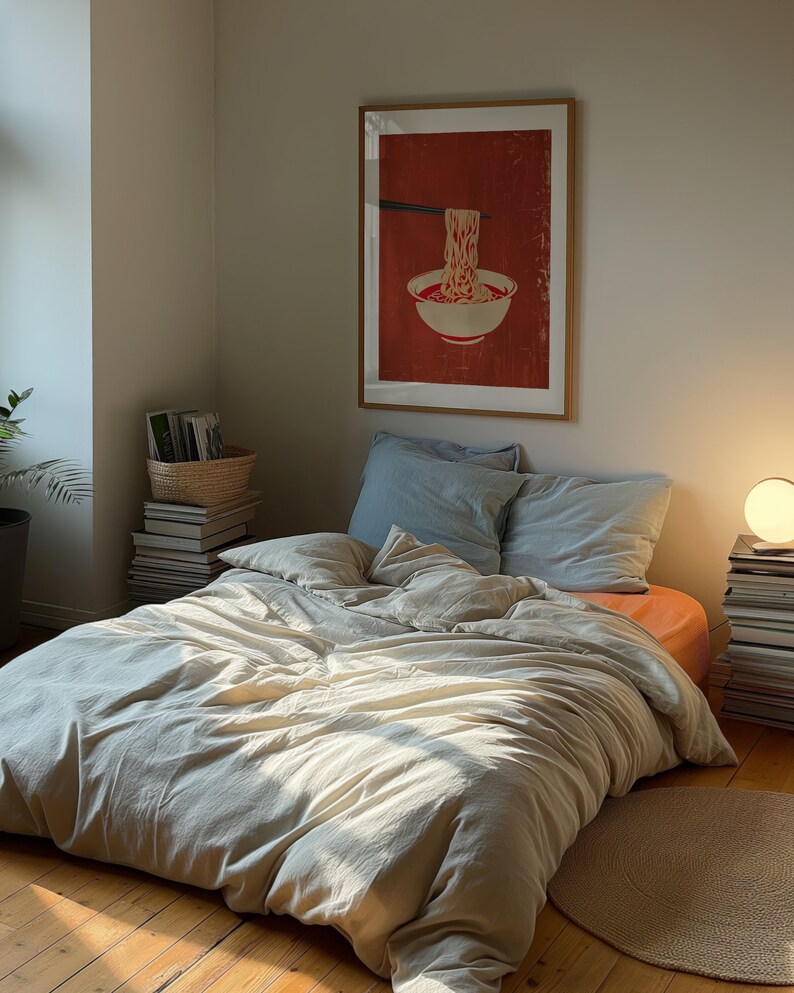 A dark moody bedroom with a floor bed. A large wood oak frame in on the wall above the bed.