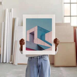 An artist studio room interior. A woman artist holds up a poster in front of her face. Concrete floor. Paper rolls and blank art canvas. Large warehouse windows, sunlight streams in