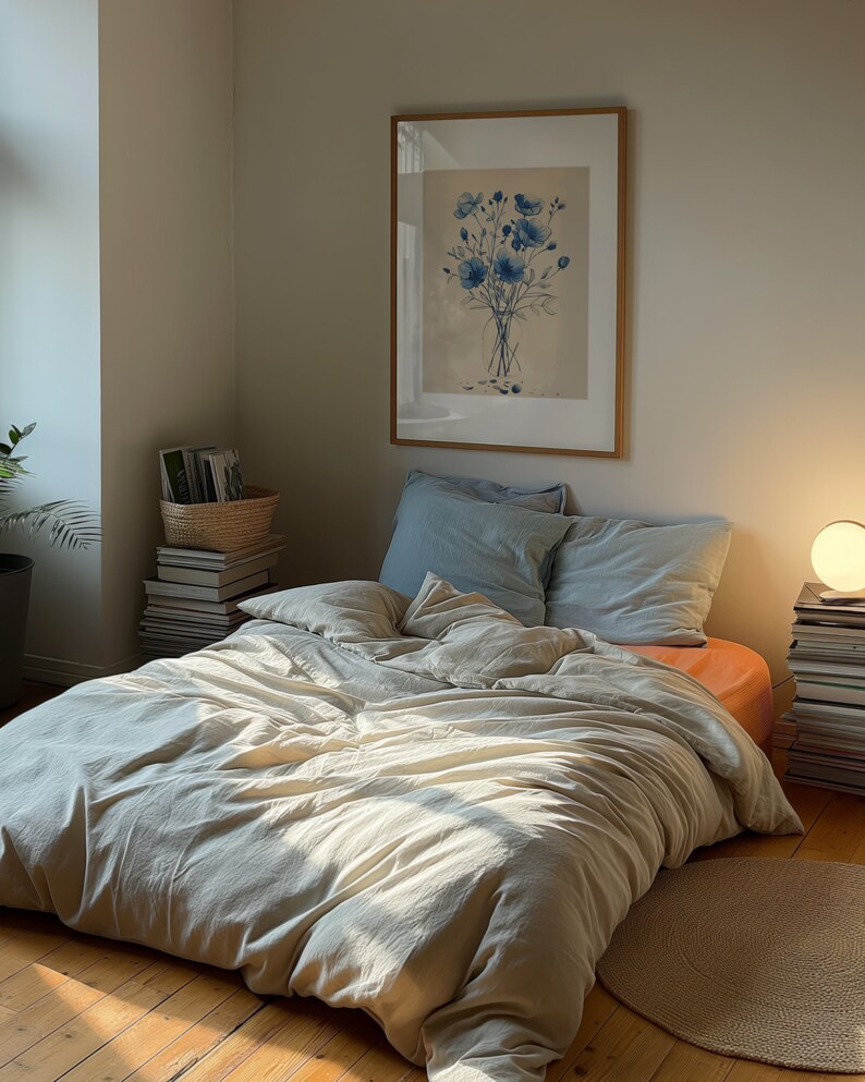 A dark moody bedroom with a floor bed. A large wood oak frame in on the wall above the bed.