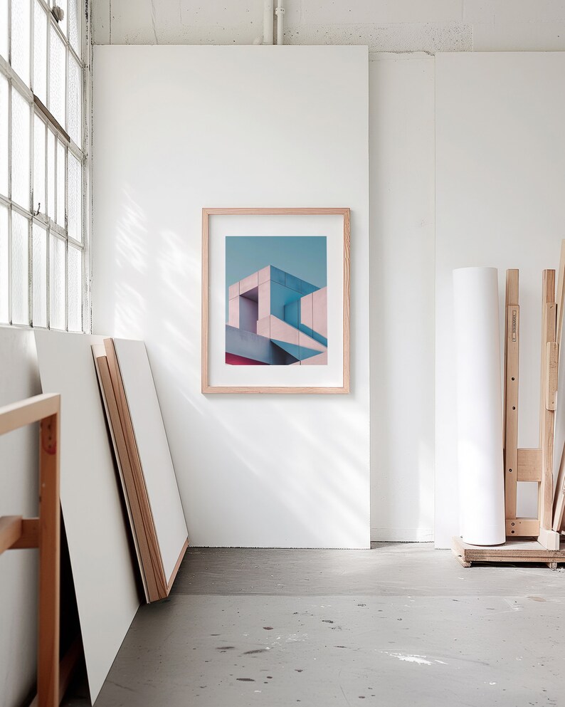 A blank thin oak wood frame mockup, in a minimal bright artist studio, with rolls of art paper and blank canvas