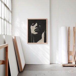 A blank thin oak wood frame mockup, in a minimal bright artist studio, with rolls of art paper and blank canvas