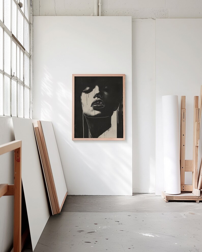 A blank thin oak wood frame mockup, in a minimal bright artist studio, with rolls of art paper and blank canvas