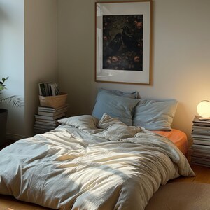 A dark moody bedroom with a floor bed. A large wood oak frame in on the wall above the bed.