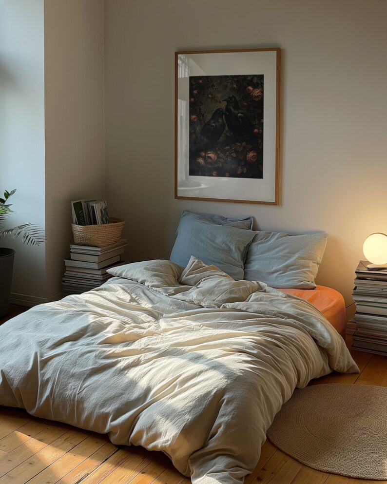 A dark moody bedroom with a floor bed. A large wood oak frame in on the wall above the bed.