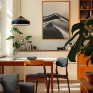 A cosy corner of a neutral wood kitchen with sunlight streaming in. A large framed artwork in on the wall
