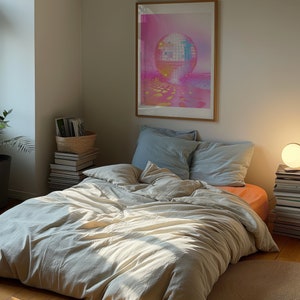 A dark moody bedroom with a floor bed. A large wood oak frame in on the wall above the bed.