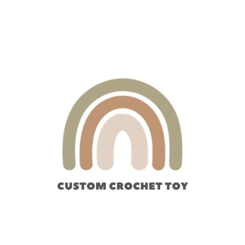 May include: A logo featuring a stylized rainbow in muted earth tones: olive green, brown, and beige. The text "CUSTOM CROCHET TOY" is printed in a dark grey, sans-serif font below the rainbow graphic, set against a white background.