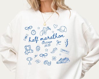 May include: White sweatshirt with a blue graphic design that says "half marathon Chicago 2025" and includes running-themed illustrations.