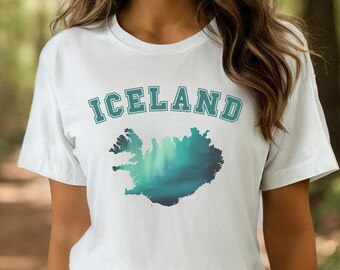 May include: White t-shirt with a green and blue outline of Iceland and the text "ICELAND" in a collegiate font.