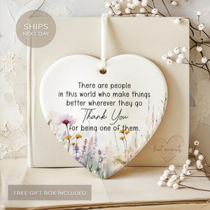 May include: White ceramic heart-shaped ornament with a floral design and the text "There are people in this world who make things better wherever they go Thank You for being one of them."