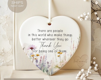 May include: White ceramic heart-shaped ornament with a floral design and the text "There are people in this world who make things better wherever they go Thank You for being one of them."
