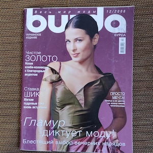 May include: A magazine cover featuring a woman wearing a green and brown dress. The magazine is titled "Buda" and the text "Чистое Золото" is visible on the cover. The magazine is a Ukrainian publication.