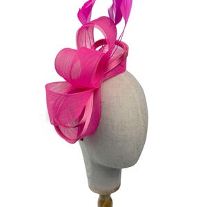 Nuovo cerchietto rosa acceso e clip a forma di fiocco in rete con dettagli di anelli e piume