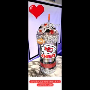 K&ouml;nnte beinhalten: Ein silberner und roter Kansas City Chiefs Becher mit Strasssteinen und einem Fu&szlig;ball-Anh&auml;nger. Der Becher ist mit Eis gef&uuml;llt und hat einen roten und schwarzen Strohhalm.
