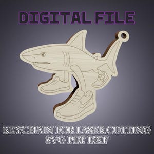 Peut inclure: Un porte-clés en bois en forme de requin avec des baskets, conçu pour la découpe laser. Le design comprend le texte "DIGITAL FILE" en haut et "KEYCHAIN FOR LASER CUTTING SVG PDF DXF" en bas. Le requin est de couleur marron clair.