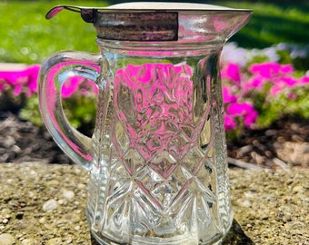 Vintage 1940s Anchor Hocking glass syrup pitcher with hinged metal lid.