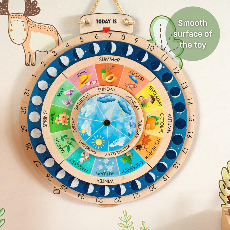 May include: Wooden educational calendar with a circular design. It features rotating discs for months, days, and seasons, with colorful illustrations and the text "TODAY IS". The calendar is suspended by a natural rope.