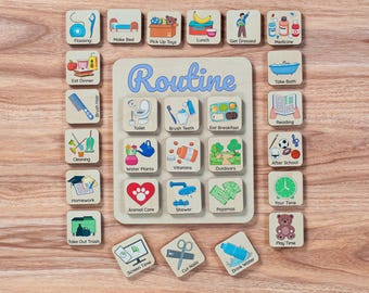 Op de afbeelding: Een houten visueel schema met kleurrijke illustraties en tekst voor dagelijkse routines. Het schema omvat activiteiten zoals flossen, bed opmaken, ontbijt eten, baden en spelen. De tekst "Routine" staat in het blauw op het bord.