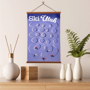 May include: A vintage-style poster with the text "Ski Utah" in white lettering on a blue background. The poster features a stylized illustration of skiers on a mountain slope.