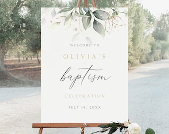 May include: A white sign on a wooden easel with the text "Welcome to Olivia's Baptism Celebration" in gold and black script. The sign is decorated with green leaves and gold accents. The date July 14, 20XX is also displayed.