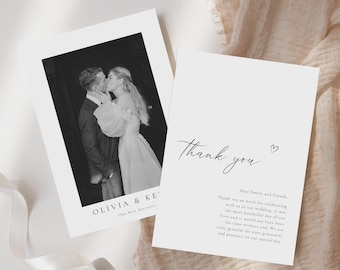 May include: Black and white wedding thank you card with a photo of a couple kissing. The card reads "Thank you" with a heart symbol and "Dear family and friends, Thank you so much for celebrating with us at our wedding. It was the most wonderful day of our lives and it would not have been the same without you! We are truly grateful for your generosity and presence on our special day."