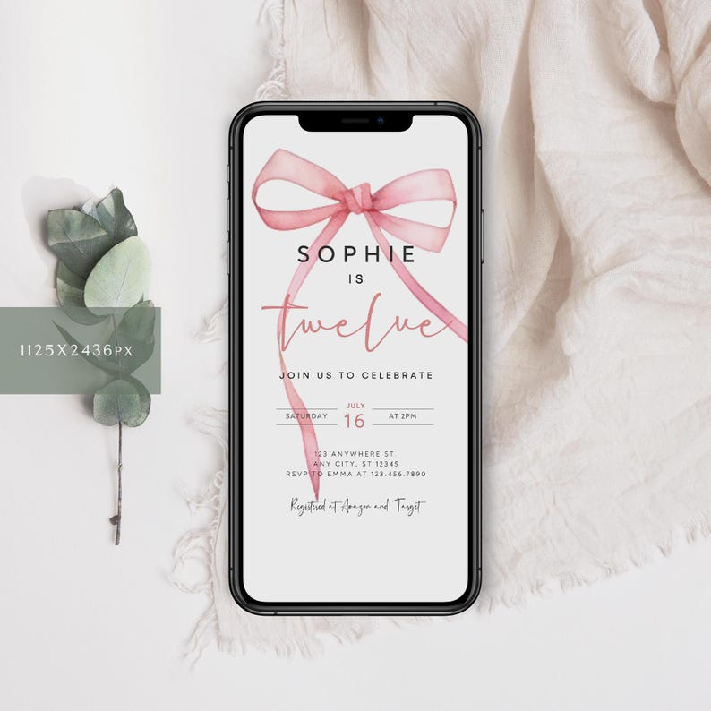 May include: A pink watercolor bow with a white background and the text "Sophie is twelve" on a smartphone screen. The text below the bow reads "Join us to celebrate" and includes the date and time of the event. The text at the bottom of the screen reads "Registered at Amazon and Target".