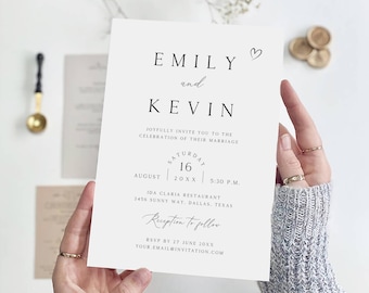 Puede incluir: Una invitación de boda blanca con texto negro, sostenida por manos. La invitación dice "EMILY y KEVIN" e incluye detalles de la boda: fecha, hora y lugar. Un pequeño corazón está encima de los nombres. Sellos de cera dorados en el fondo.