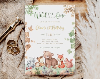 May include: A woodland-themed first birthday party invitation with a green heart and the text "Wild One". The invitation features a watercolor illustration of a bear, fox, raccoon, deer, and squirrel. The text "Oliver's 1st Birthday" is in gold lettering. The invitation includes the date, time, and location of the party, as well as the RSVP information and the registry information.