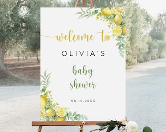 May include: A white welcome sign with a lemon and greenery design. The sign reads "Welcome to Olivia's Baby Shower 08.10.20XX".