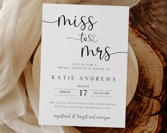 May include: A white bridal shower invitation with black text. The invitation reads "Miss to Mrs" with a heart symbol. The invitation includes the bride's name, the date and time of the shower, and the location. It also includes the RSVP information and the registry information.
