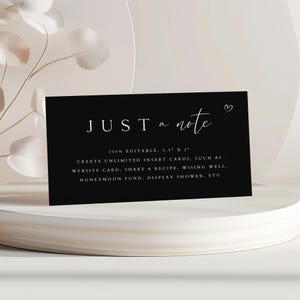 May include: Black card with white text that reads "JUST a note" with a small heart symbol. The text below reads "100% EDITABLE, 3.5" X 2" CREATE UNLIMITED INSERT CARDS, SUCH AS WEBSITE CARD, SHARE A RECIPE, WISHING WELL, HONEYMOON FUND, DISPLAY SHOWER, ETC"