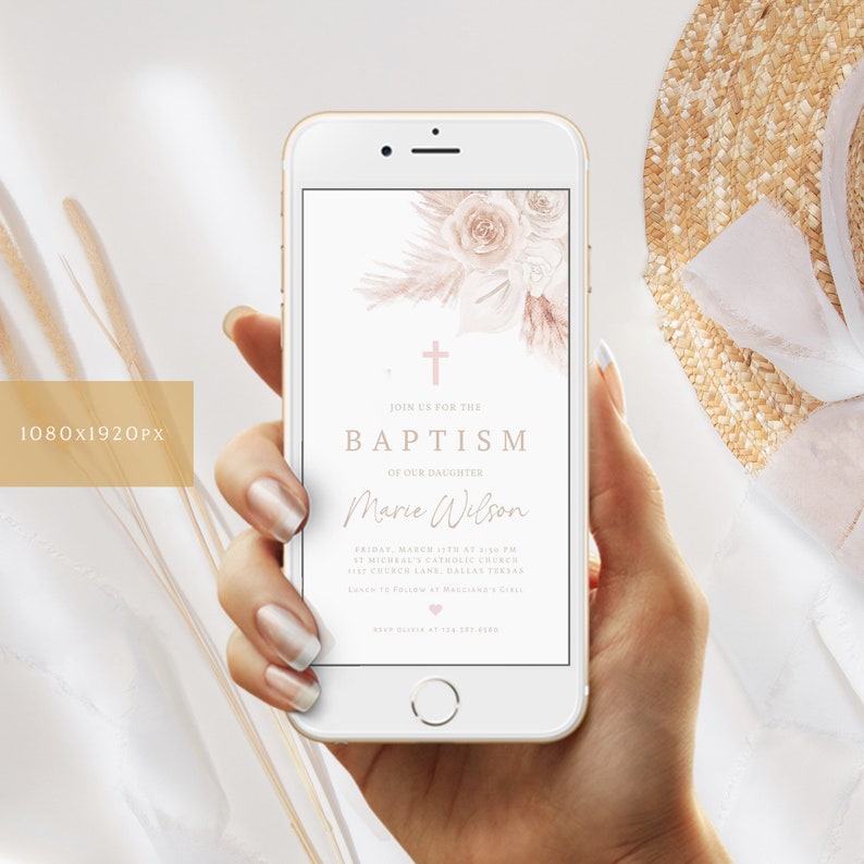 May include: A smartphone displays a baptism invitation. The invitation features a floral design with a cross and the text "Join us for the Baptism of our Daughter Marie Wilson". The phone is held in a hand.
